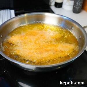 Crispy Southern Fried Catfish Recipe with Tangy Remoulade 8 Catfish frying in hot oil.
