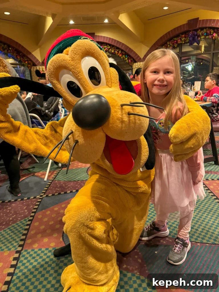 Guest at Goofy's Kitchen with the character Pluto.