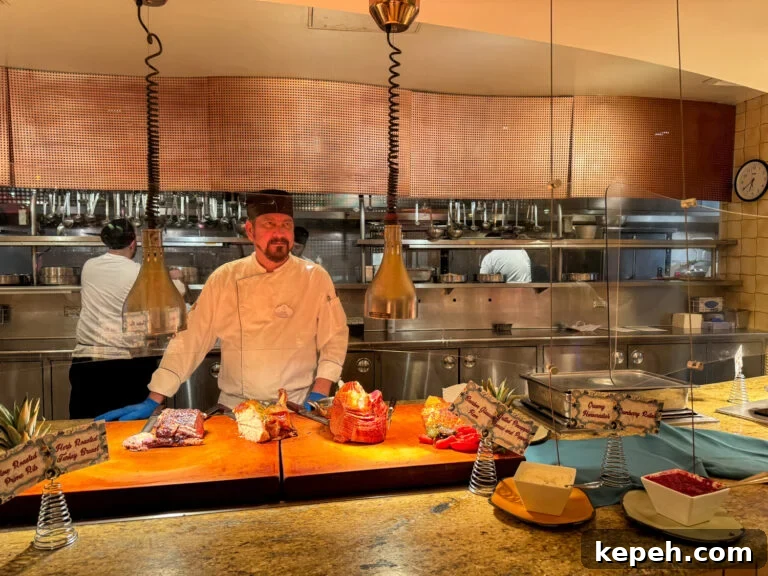 Chef at carving station with ham, pork roast and prime rib in the edge of the kitchen during dinner service.