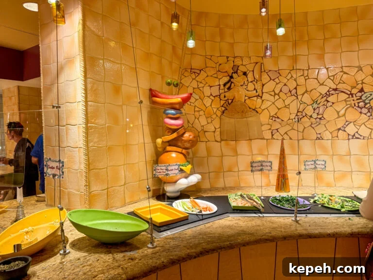 Goofy hand holding a stack of pretend food next to the salad bar at Goofy's Kitchen.