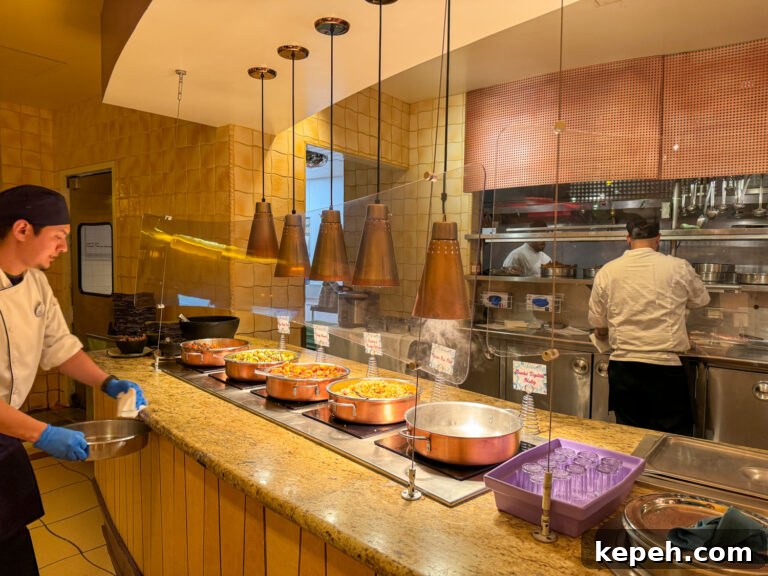Warm side dishes in large skillets under lights.
