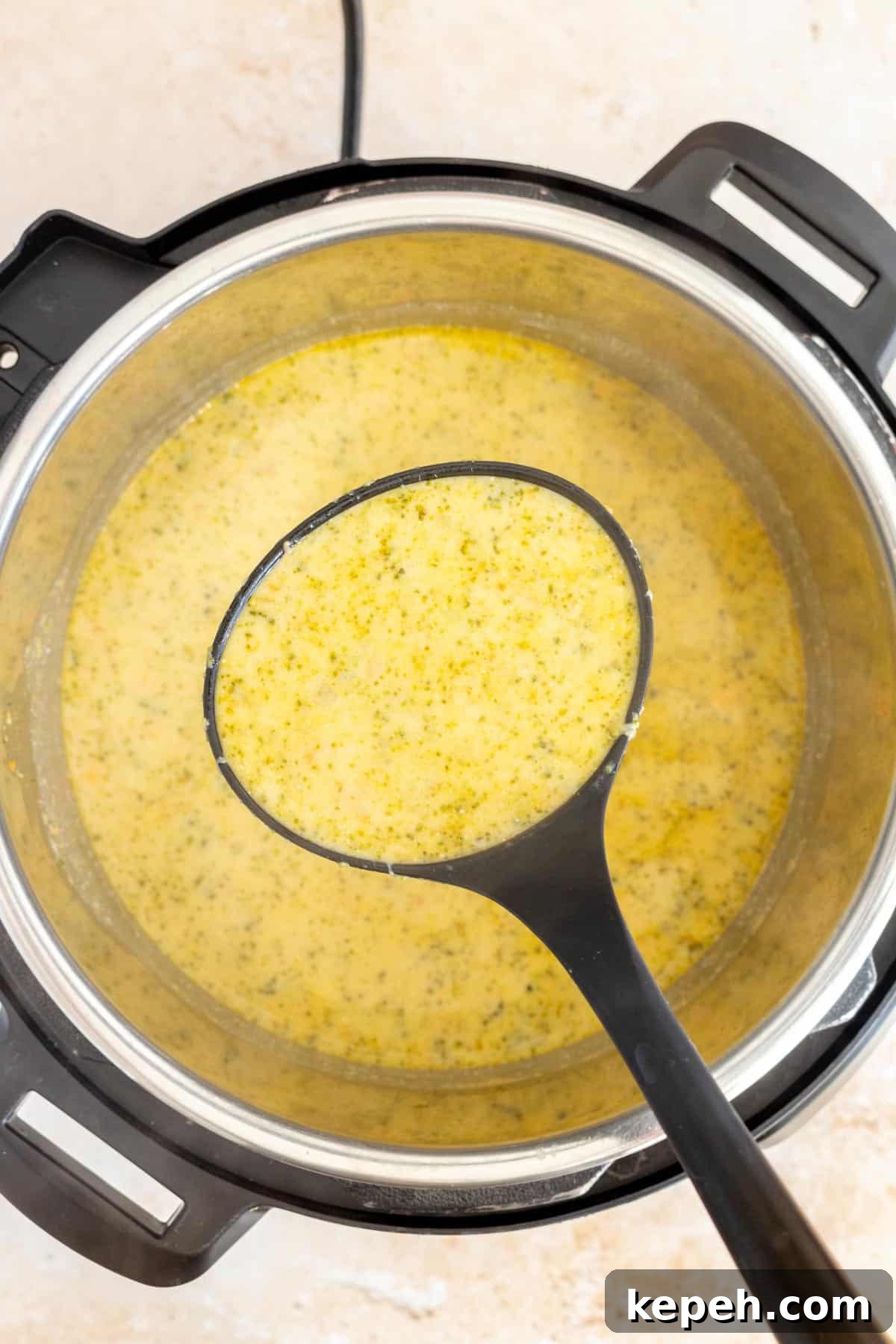 Creamy Instant Pot Broccoli and Cheddar Soup Recipe 6 A ladle of broccoli cheddar soup lifted from an Instant Pot.