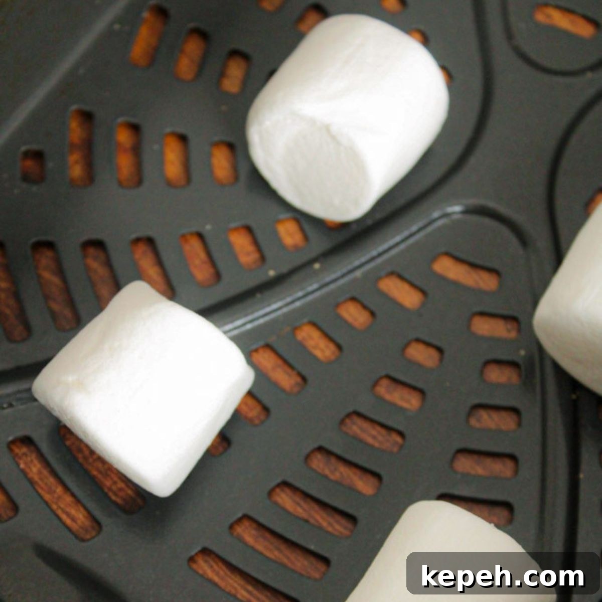 Uncooked marshmallows in an air basket, evenly spaced.
