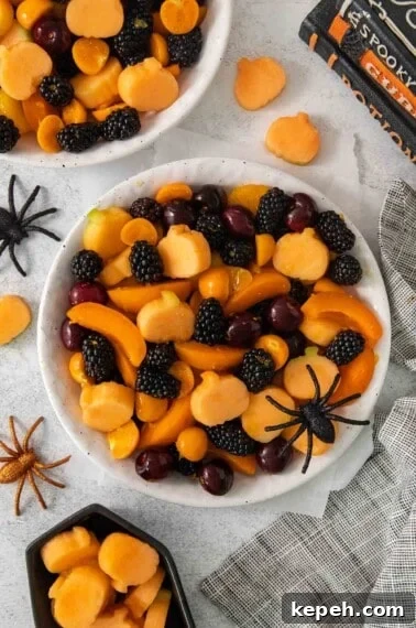 Spooky Halloween Snack Mix Recipes for Party Treats 13 An overhead view of Halloween fruit salad in a bowl