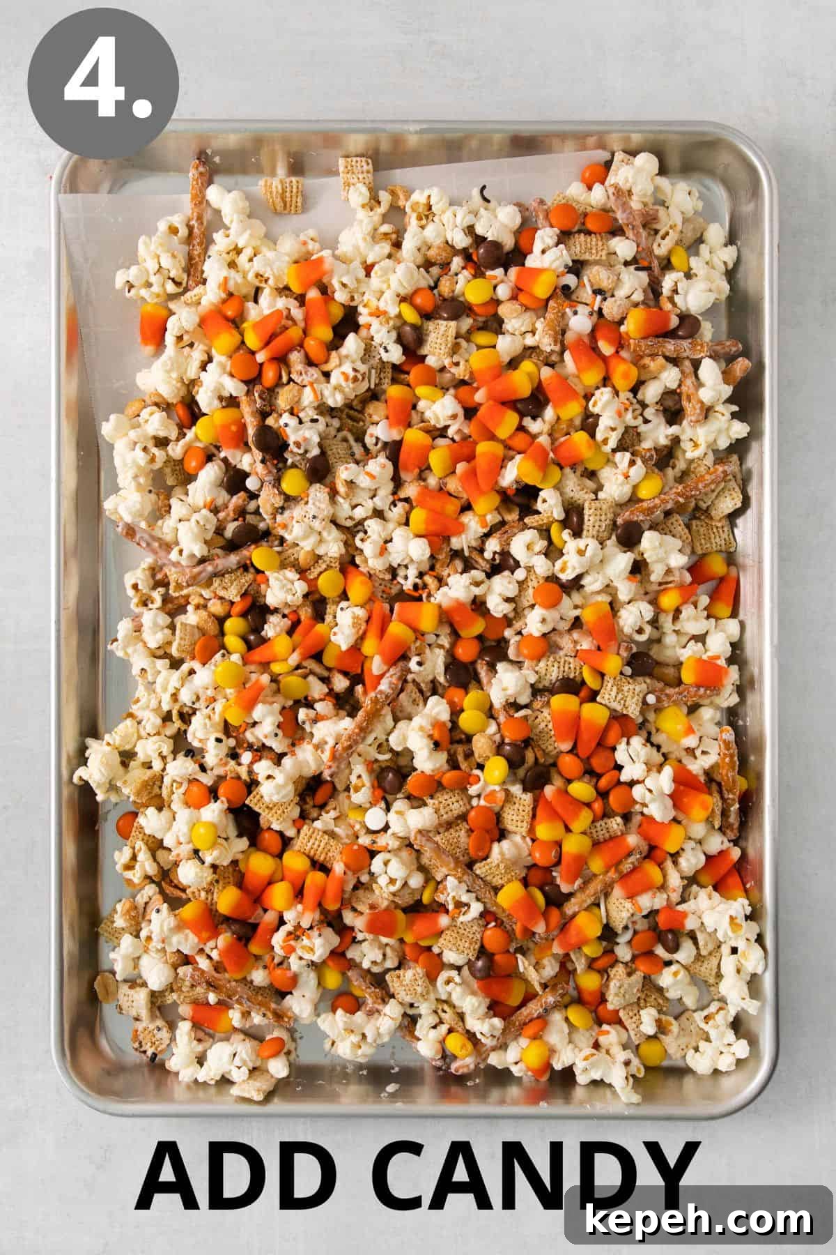 Spooky Halloween Snack Mix Recipes for Party Treats 7 Snack mix and candy added to a baking sheet