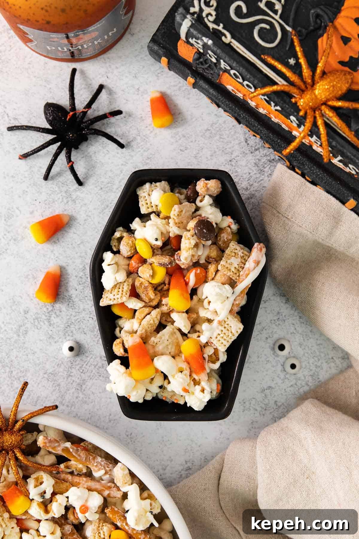 Spooky Halloween Snack Mix Recipes for Party Treats 8 Halloween snack mix in a Halloween bowl with decorations around it