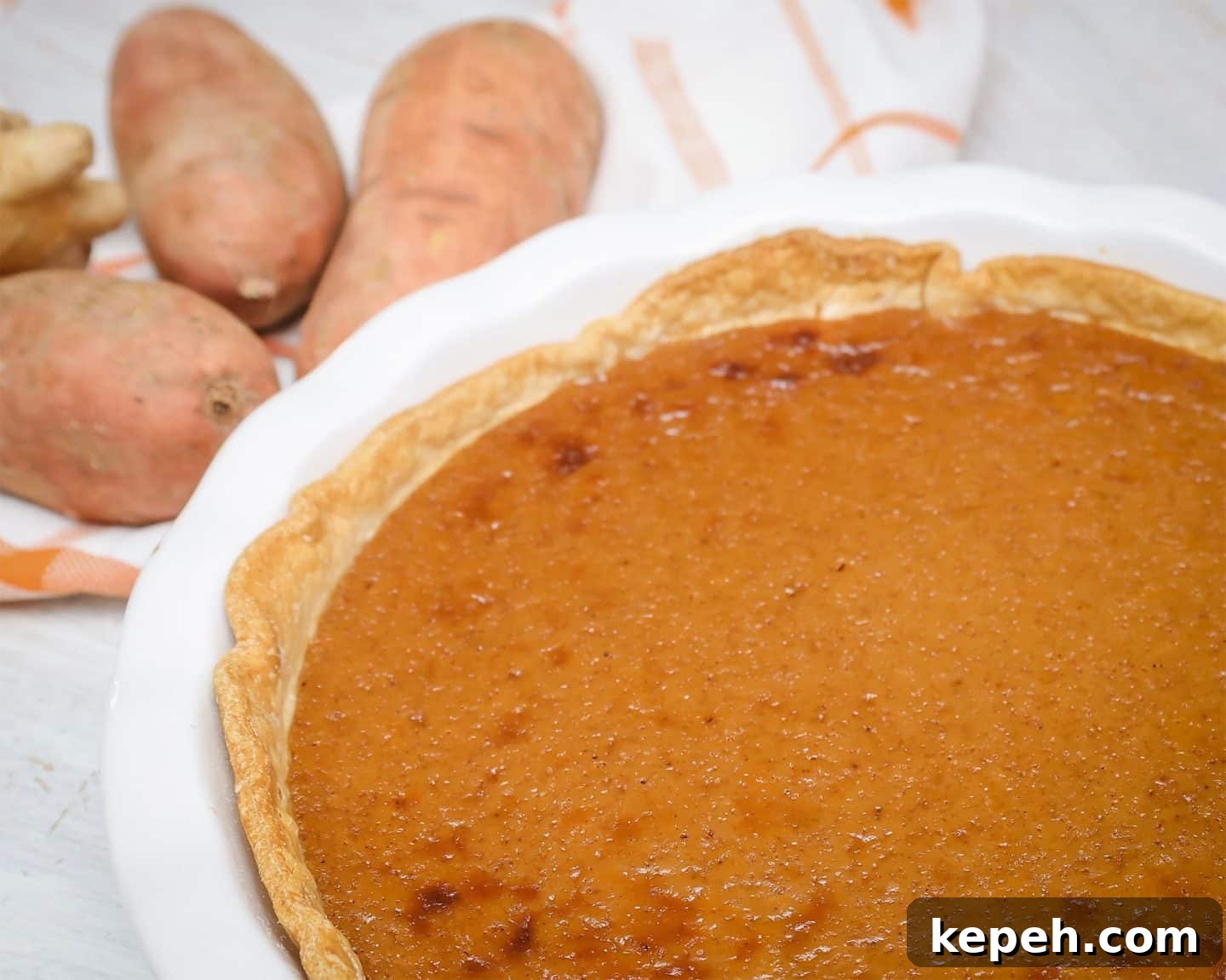 Close-up of sweet potato pie custard baked until set and smooth — demonstrating correct baking time and structure to prevent cracking, runny filling, or overbaking.