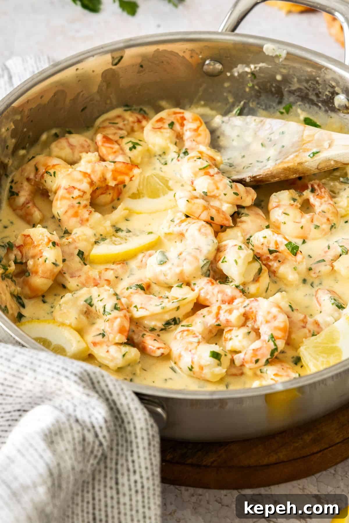 Top Easter Main Courses for a Memorable Holiday Meal 10 Frying pan with Creamy Lemon Prawns, and a wooden spoon resting in the pan.