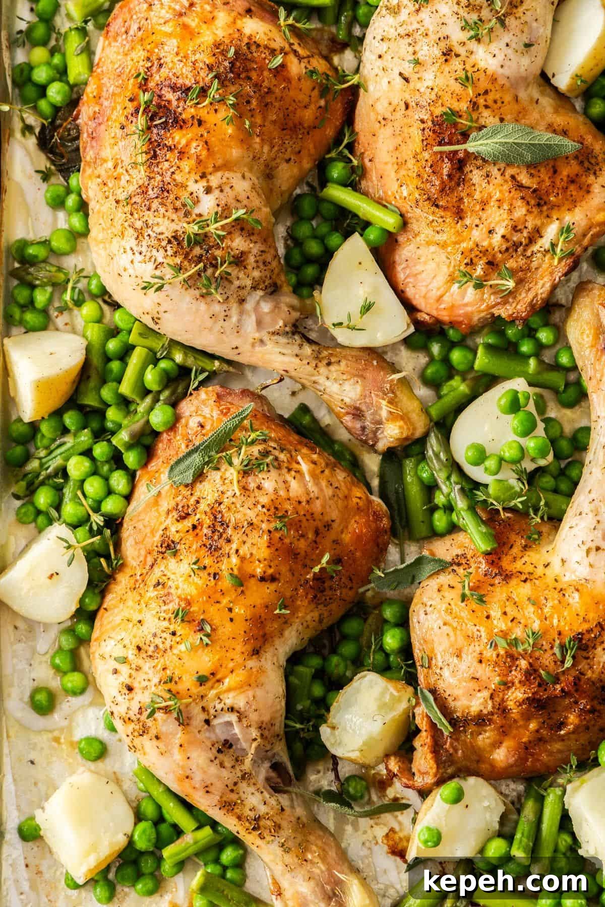 Top Easter Main Courses for a Memorable Holiday Meal 12 Roasted Chicken Marylands on a baking tray, surrounded by some cubes of potatoes, peas and green beans.