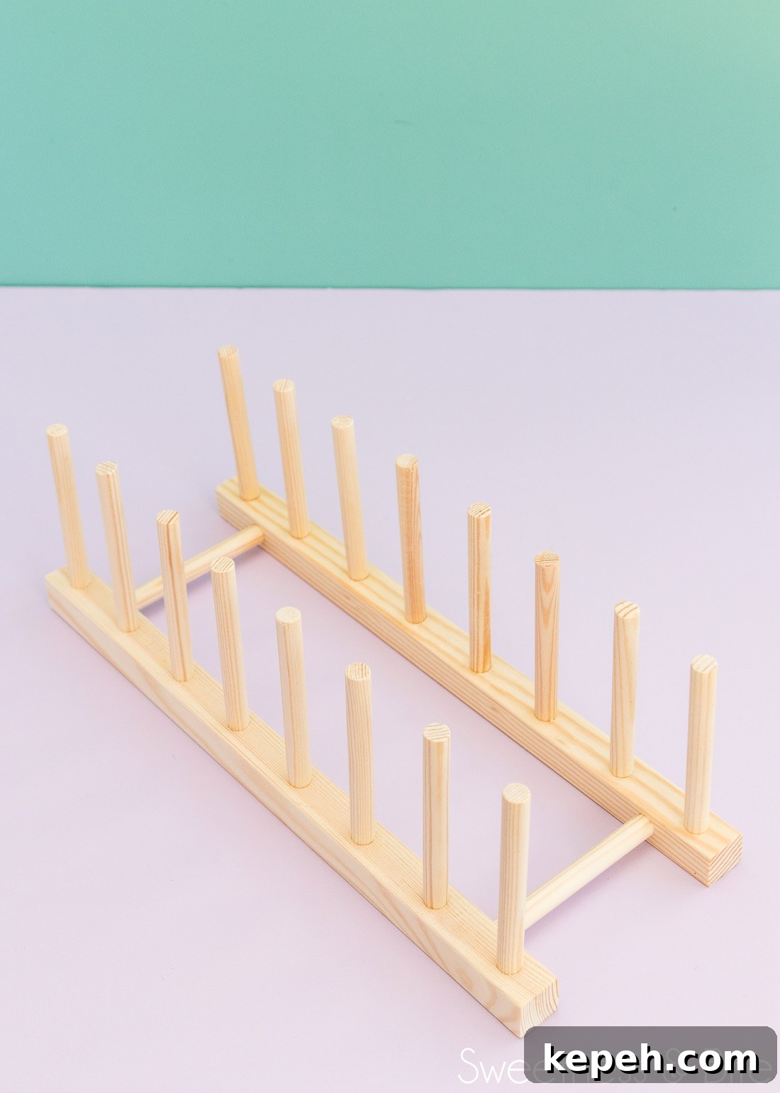 A wooden plate rack on a purple background.