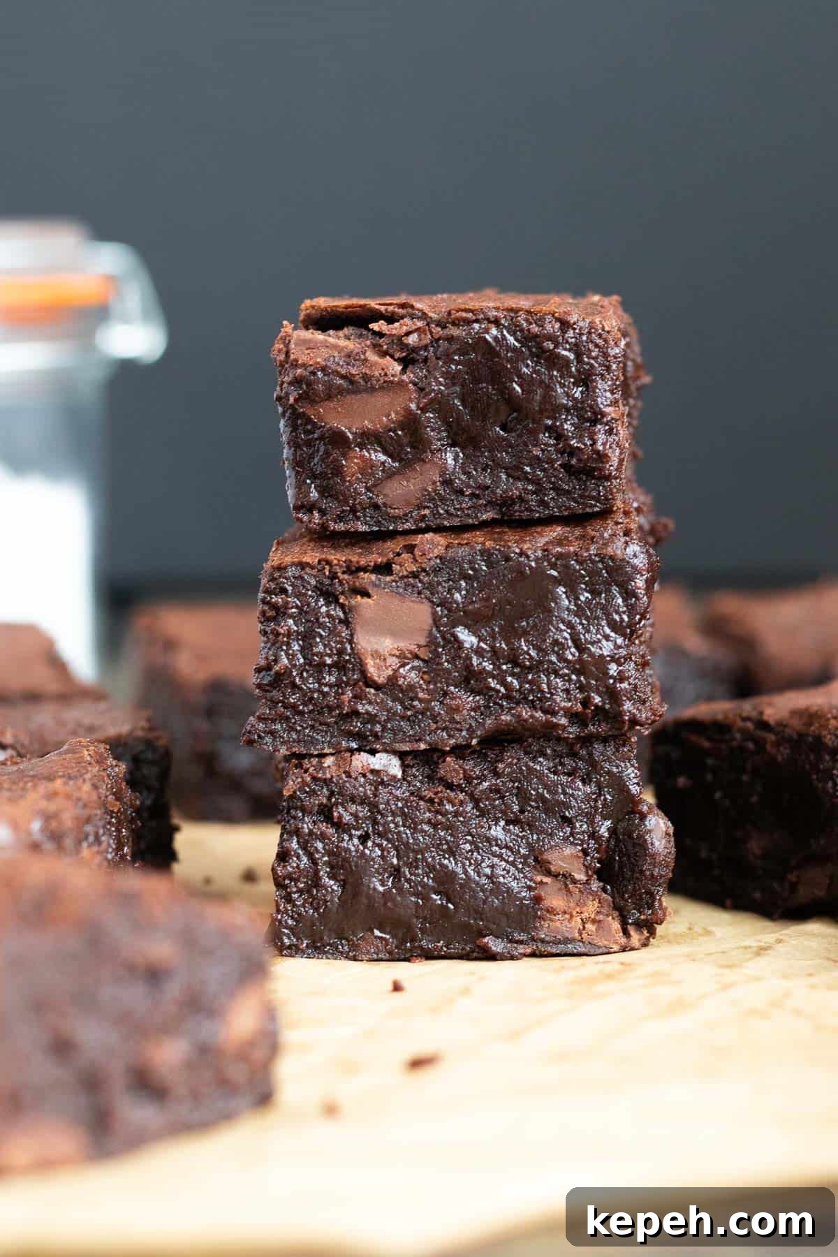 One-Bowl Dark Chocolate Brownies Recipe 2 a stack of three dark chocolate brownies against a dark background