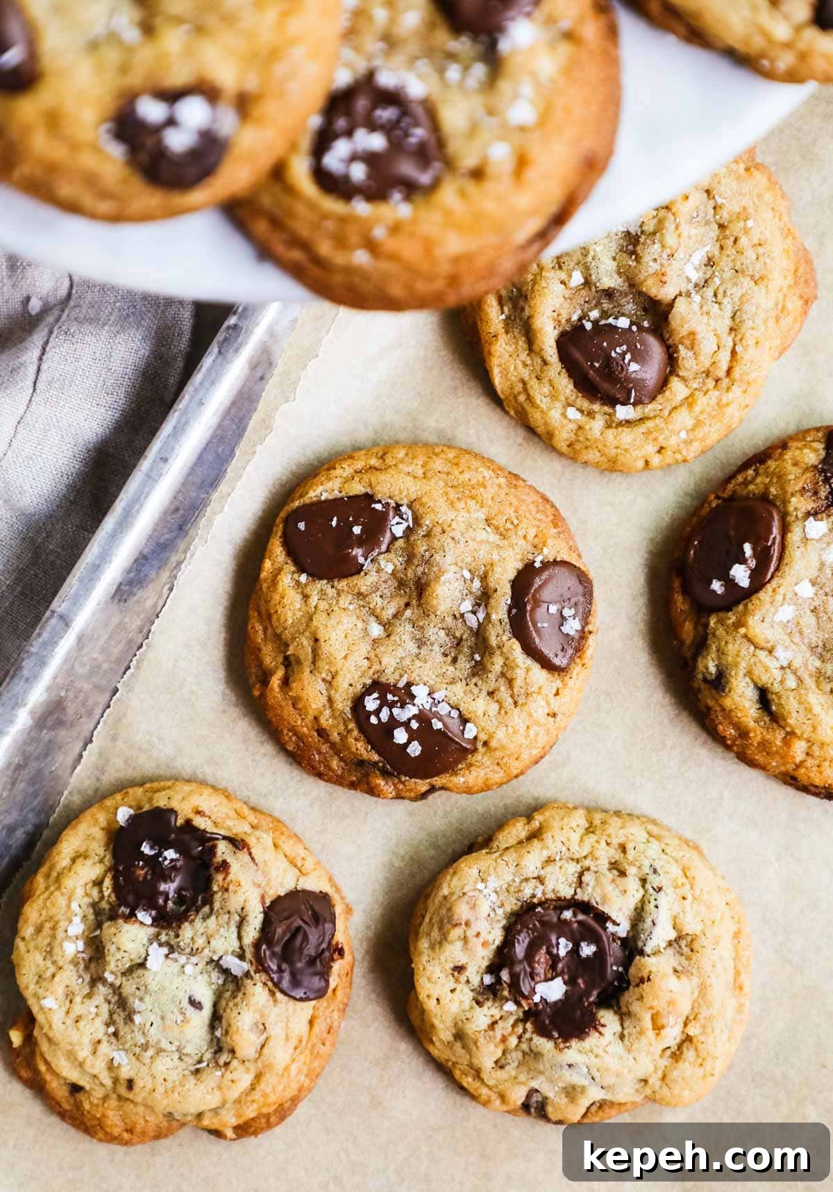 Perfect Small-Batch Chocolate Chip Cookie Recipe (Makes 6) 6 Small batch salted chocolate chip cookies on a parchment paper-lined baking sheet.