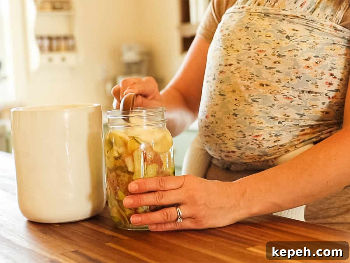 Homemade Apple Cider Vinegar Recipe for DIY Fermentation 6 Adding sugar to the jar of apple scraps and water.