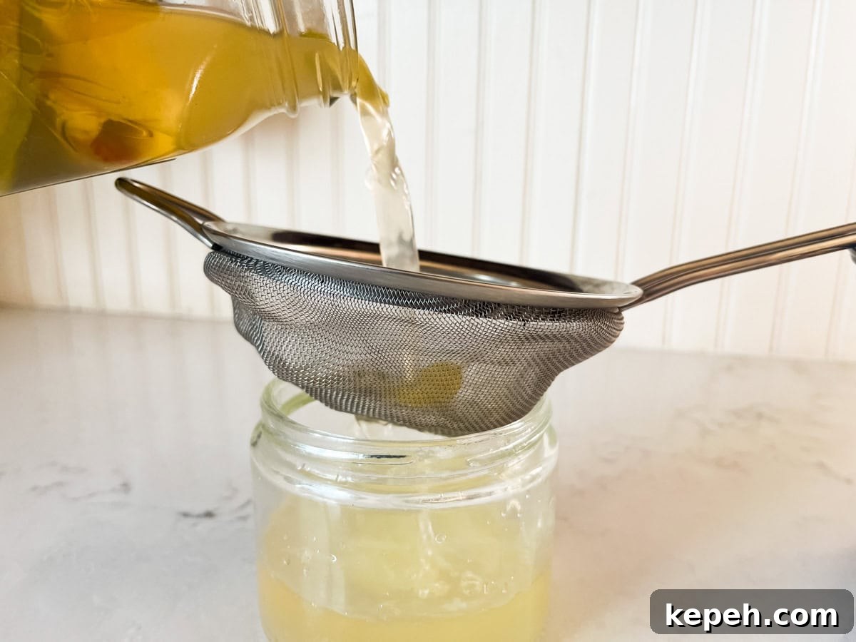 Homemade Apple Cider Vinegar Recipe for DIY Fermentation 8 Straining homemade apple cider vinegar through a fine mesh strainer.