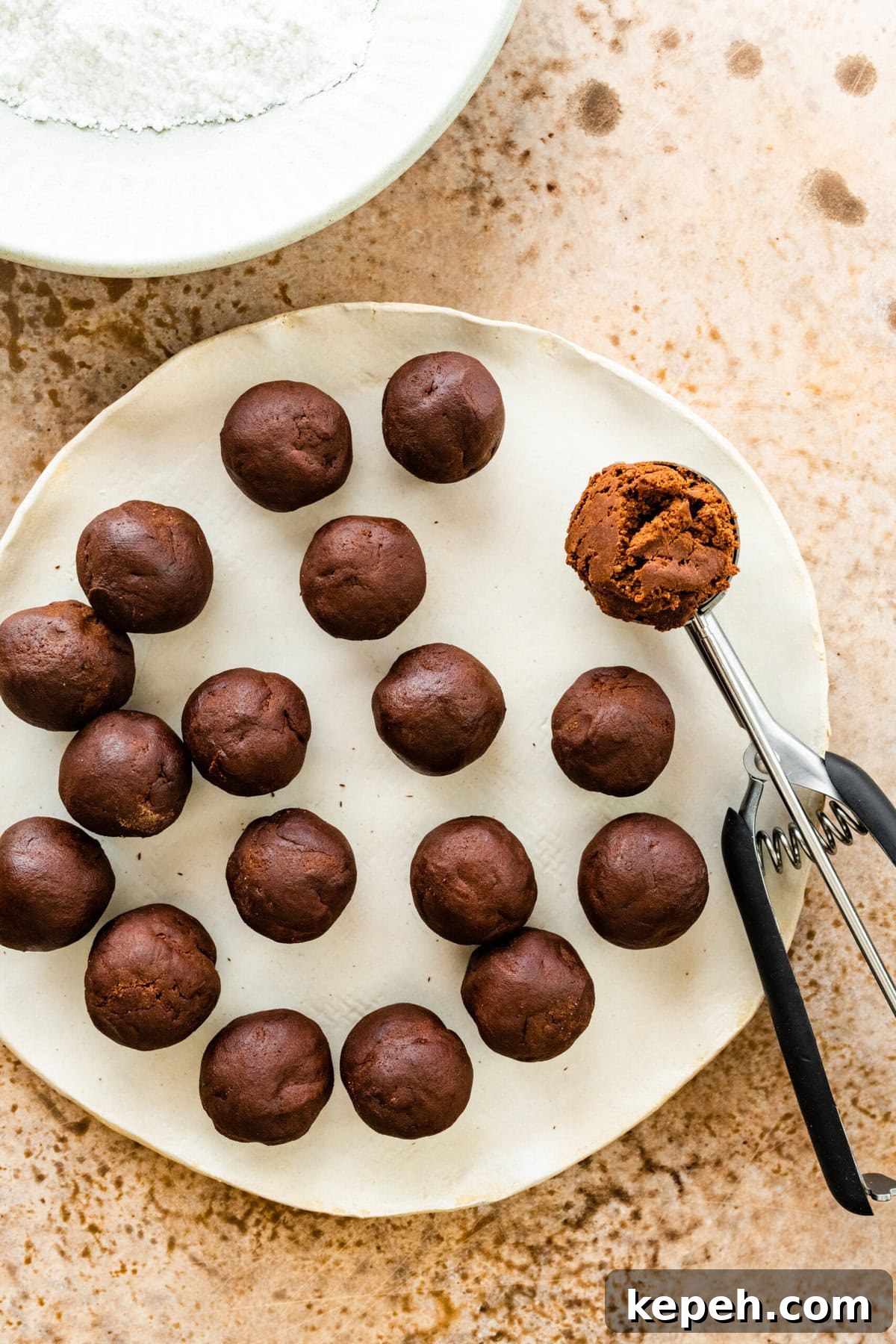 How to make chocolate crinkle cookies step-by-step: with a small cookie scoop make balls of the chocolate cookie dough.