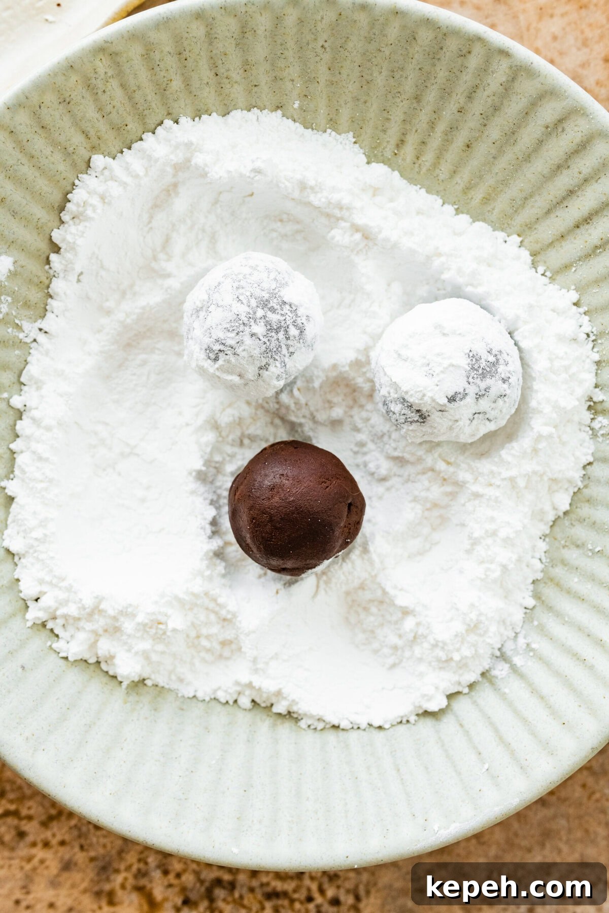 How to make chocolate crinkle cookies step-by-step: roll the cookies in the powdered sugar.