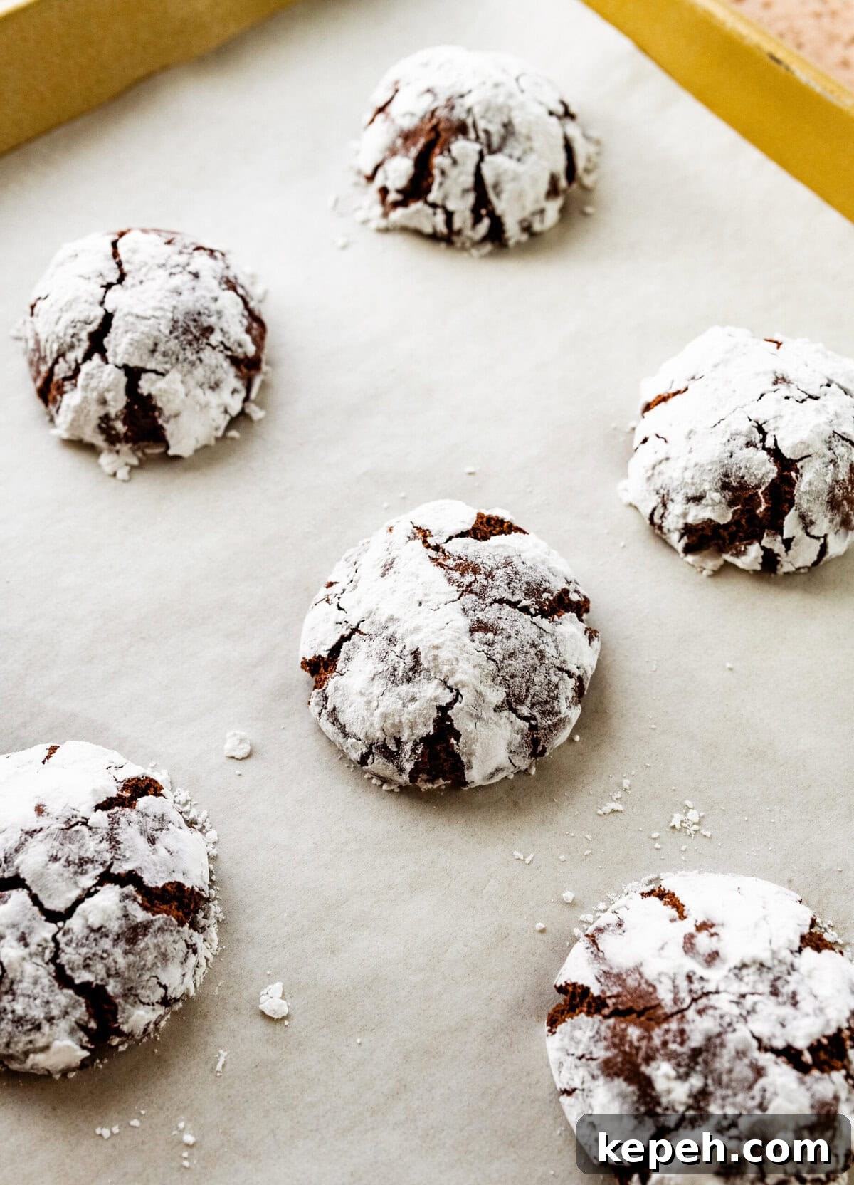 How to make chocolate crinkle cookies step-by-step: baked crinkle cookies on baking sheet.