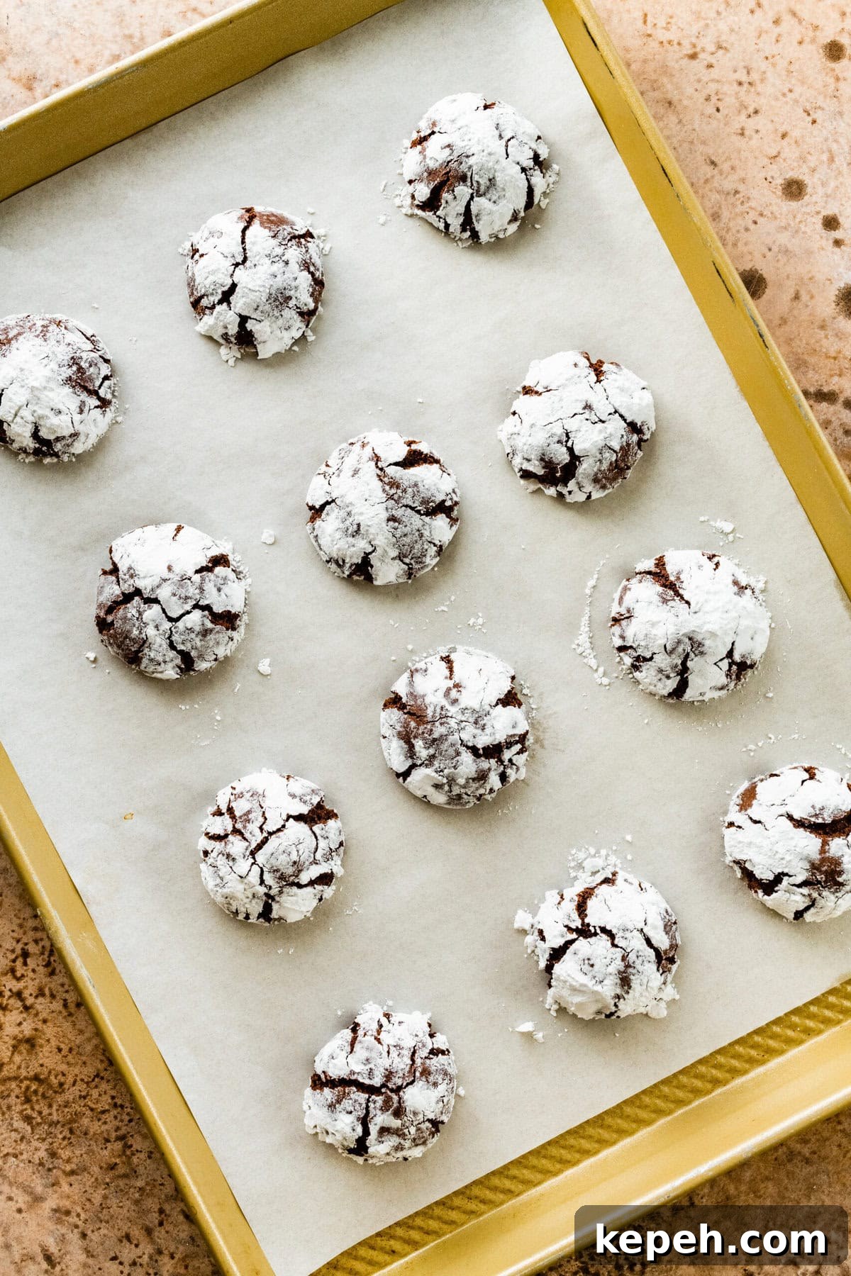 How to make chocolate crinkle cookies step-by-step: baked crinkle cookies on baking sheet.