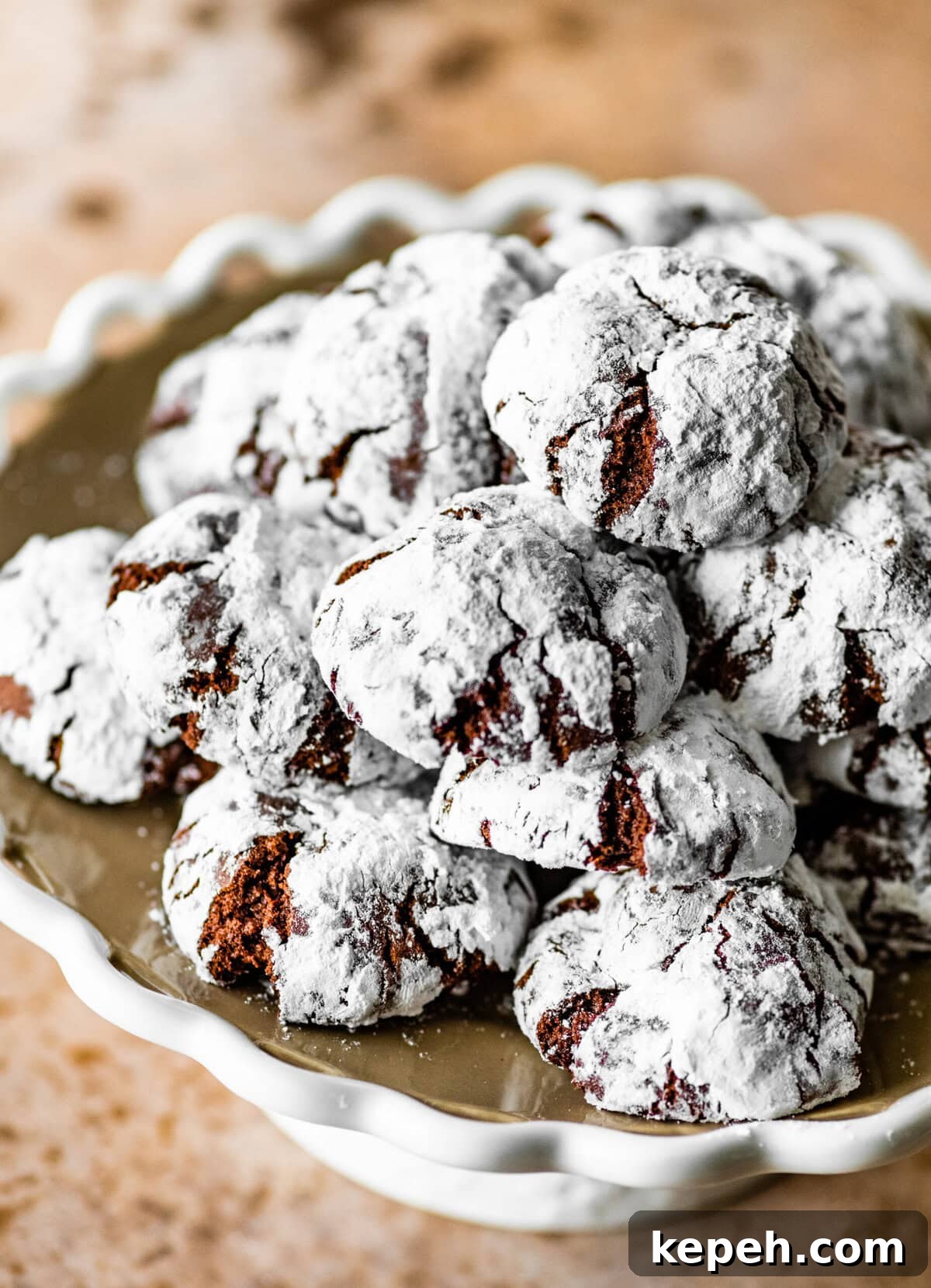 Chocolate Crinkle Cookies Recipe. Cookies on a beautiful platter ready to serve with Christmas lights in the background.