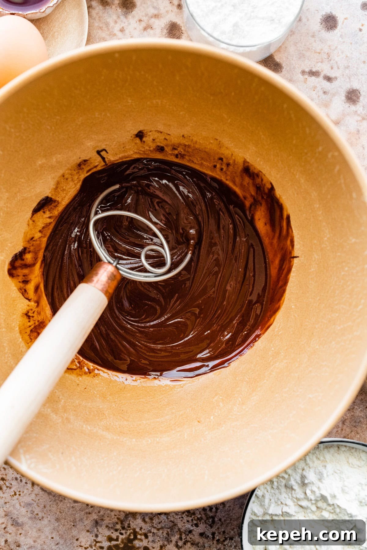 How to make chocolate crinkle cookies step-by-step: melt the chocolate and butter in a large bowl and mix to combine.