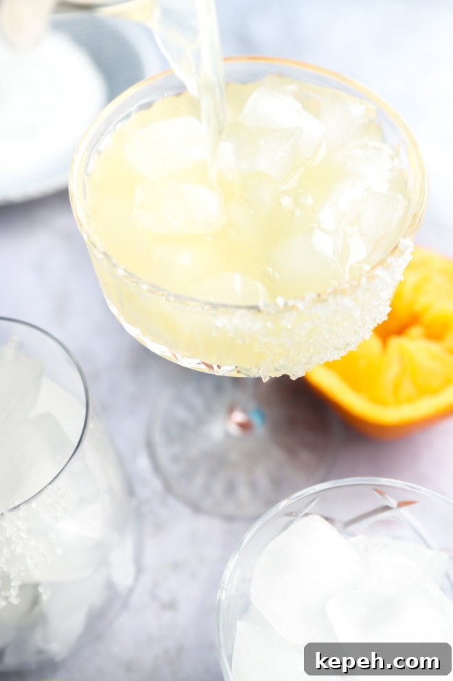 Texas Margarita Recipe: Classic Tex-Mex Cocktail Guide 7 Pouring texas margarita into a glass filled with ice image