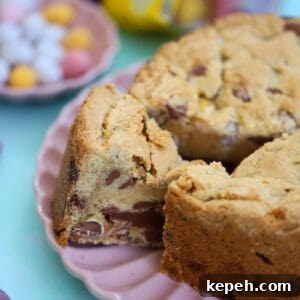 A Mini Egg Cookie Pie with a wedge taken out of it, on a pink plate.