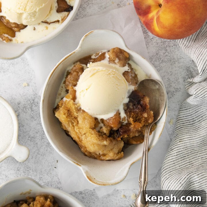 a ceramic crock filled with a serving of peach cobbler and vanilla ice cream