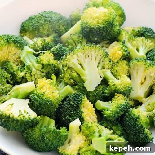 Square photo of steamed broccoli in a bowl.