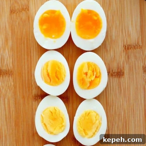 Sliced cooked eggs on a wooden cutting board.