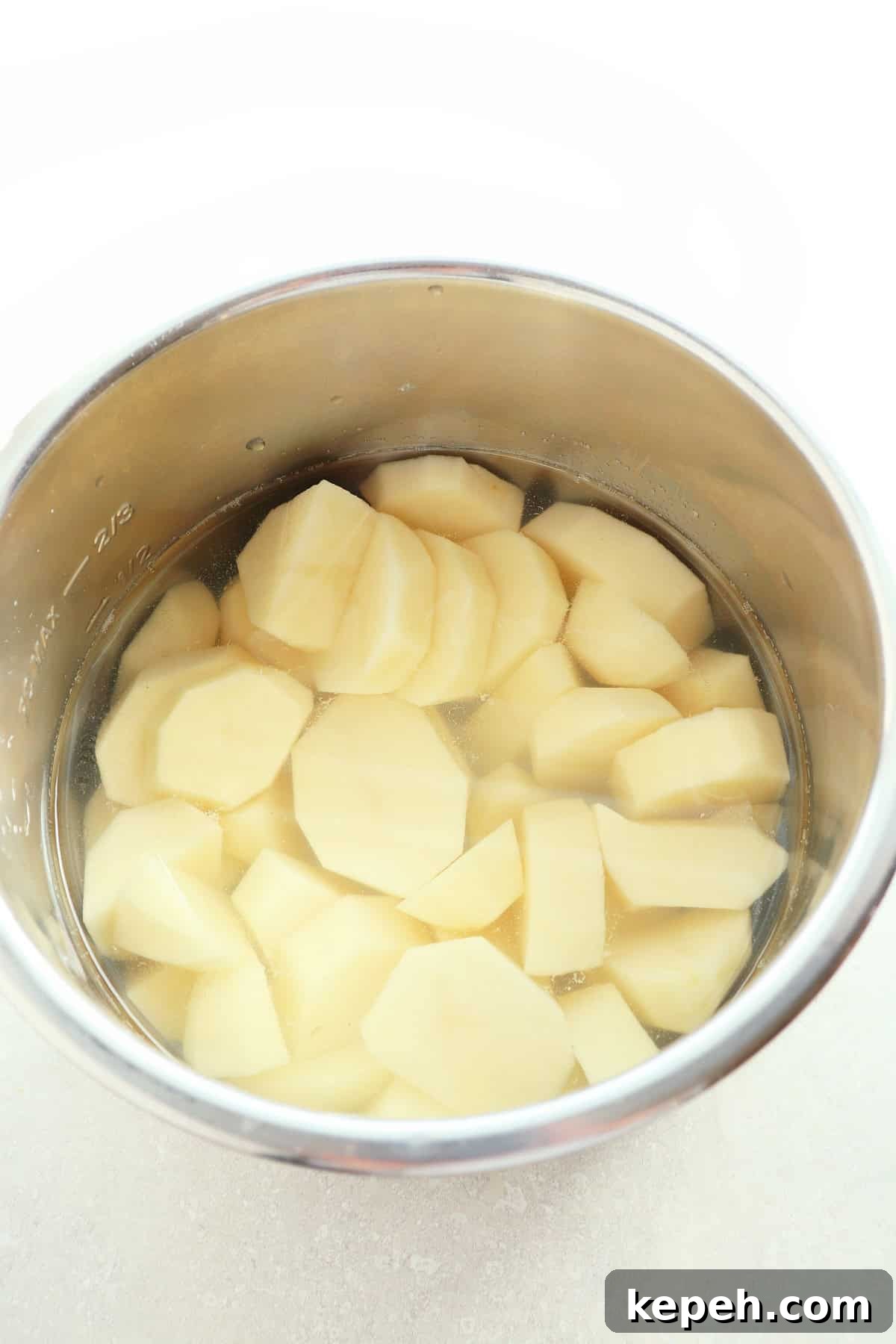 Classic Creamy Mashed Potatoes Recipe for Perfectly Smooth Results 4 Raw potatoes cut into chunks, submerged in water in the Instant Pot.