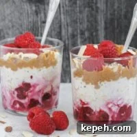 Creamy Raspberry Overnight Oats Recipe for Quick Breakfast 6 Two glass cups filled with layers of oats, raspberries, almond butter and almonds.