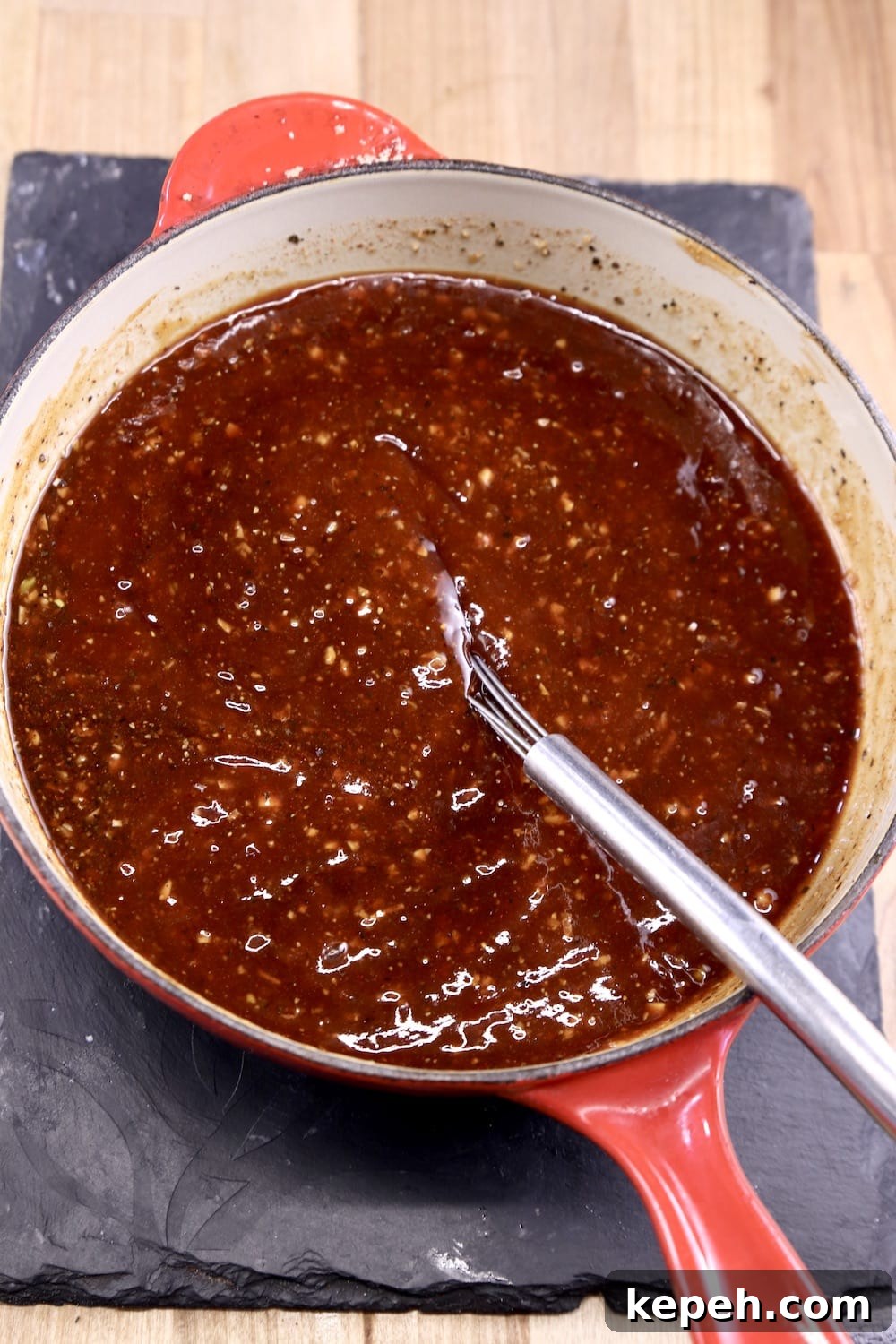 Pan of bbq sauce with a whisk
