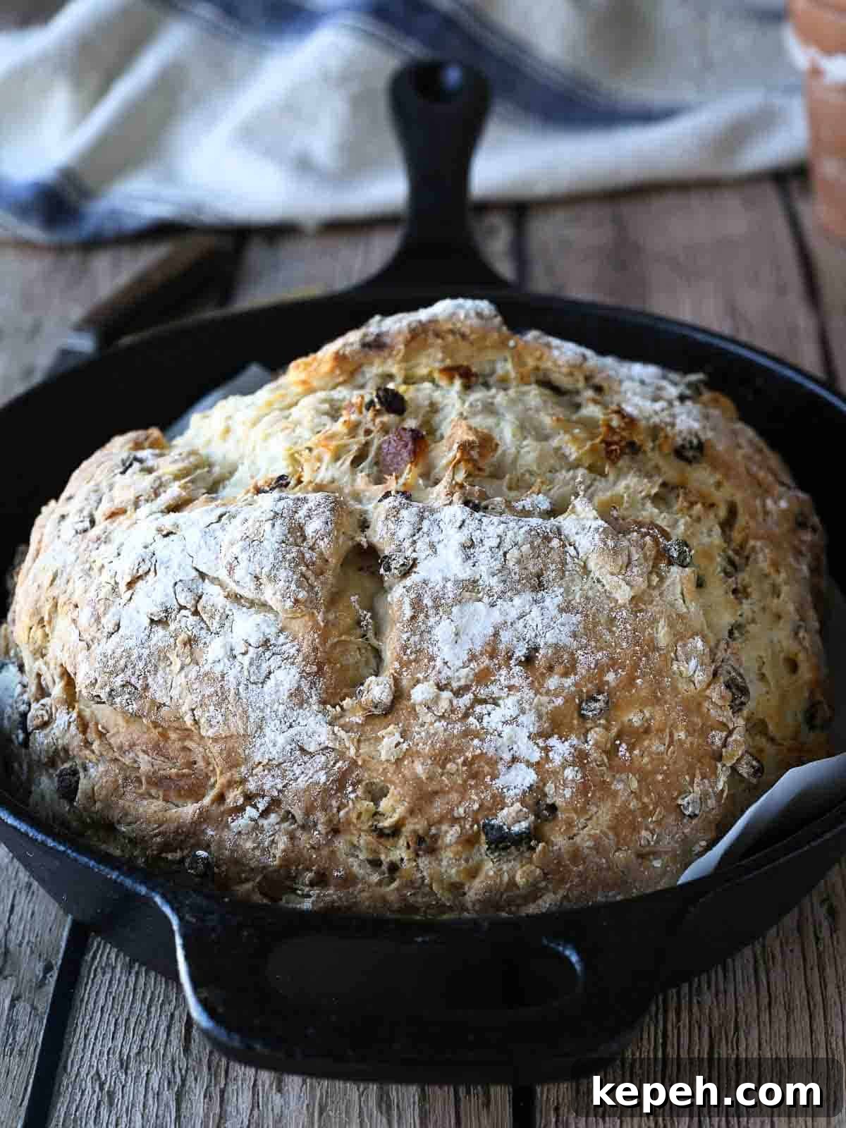 Irish soda bread in a cast iron skillet on a wood surface.