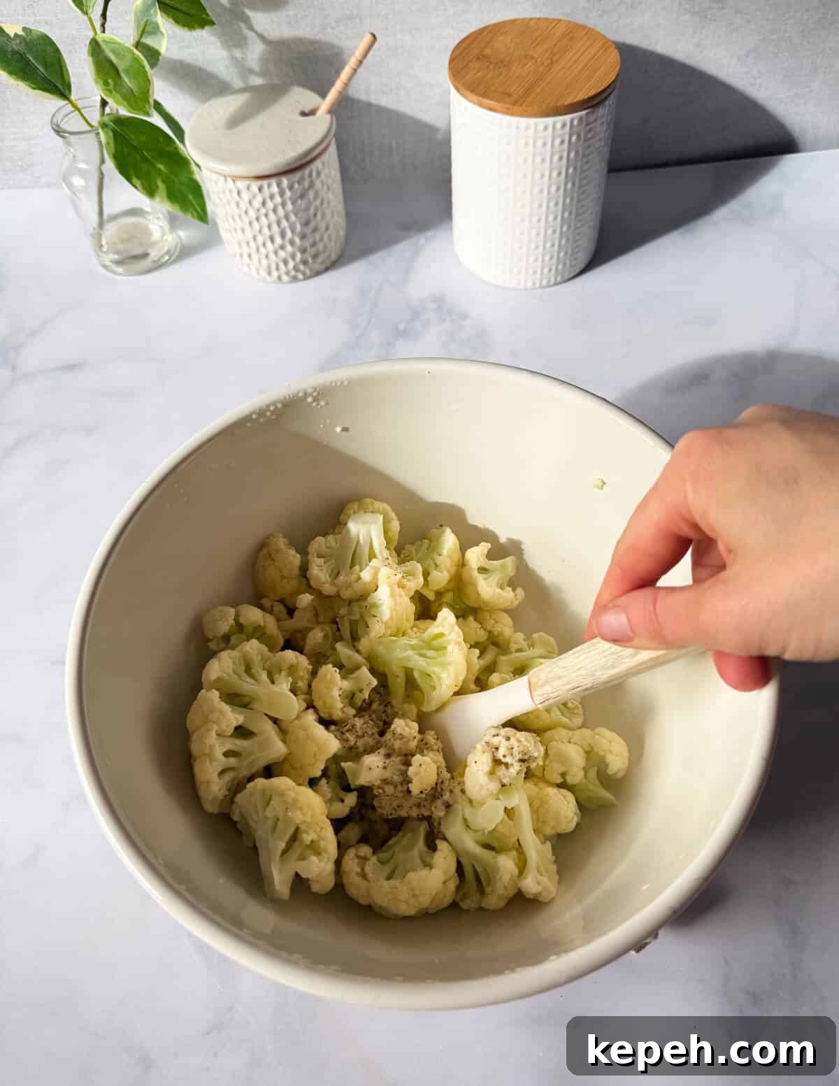 Garlic Butter Microwave Cauliflower Recipe for Quick Sides 11 stirring garlic butter into cauliflower florets with a spatula.