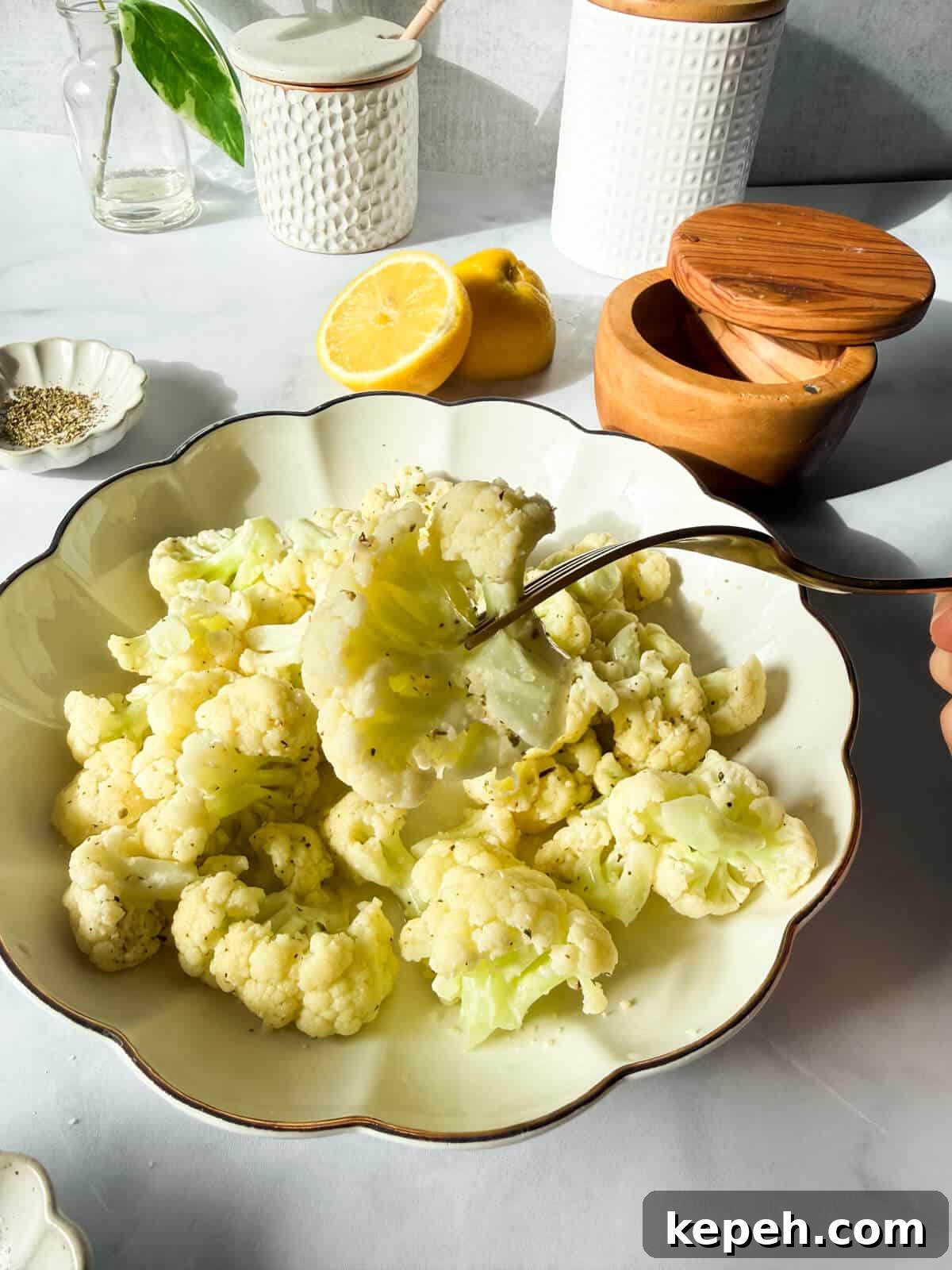 Garlic Butter Microwave Cauliflower Recipe for Quick Sides 13 fork holding a cooked cauliflower floret.