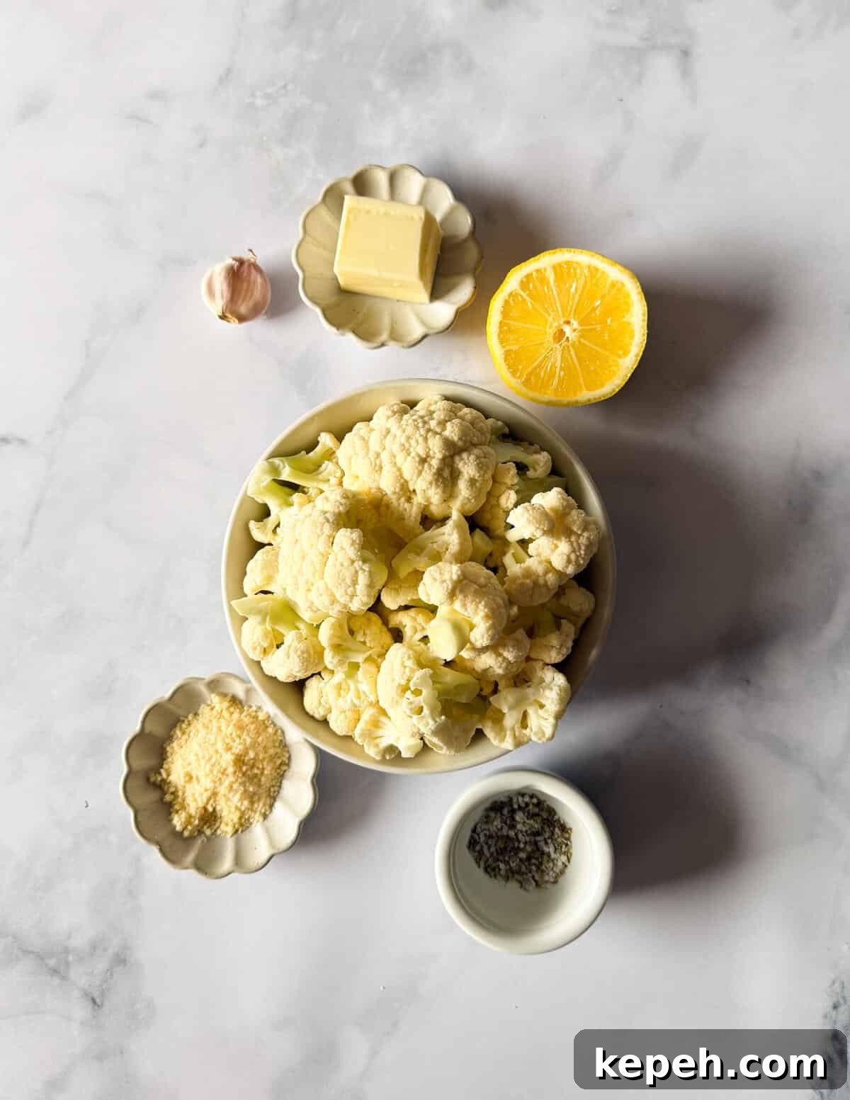 Garlic Butter Microwave Cauliflower Recipe for Quick Sides 3 a bowl of cauliflower, lemon, butter, garlic, parmesan, salt, and oregano.