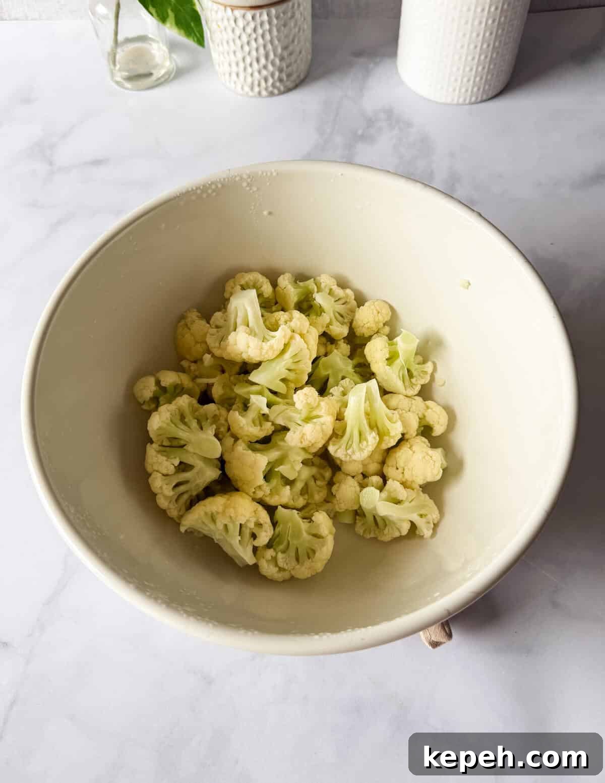 Garlic Butter Microwave Cauliflower Recipe for Quick Sides 6 cooked cauliflower florets in a large bowl.