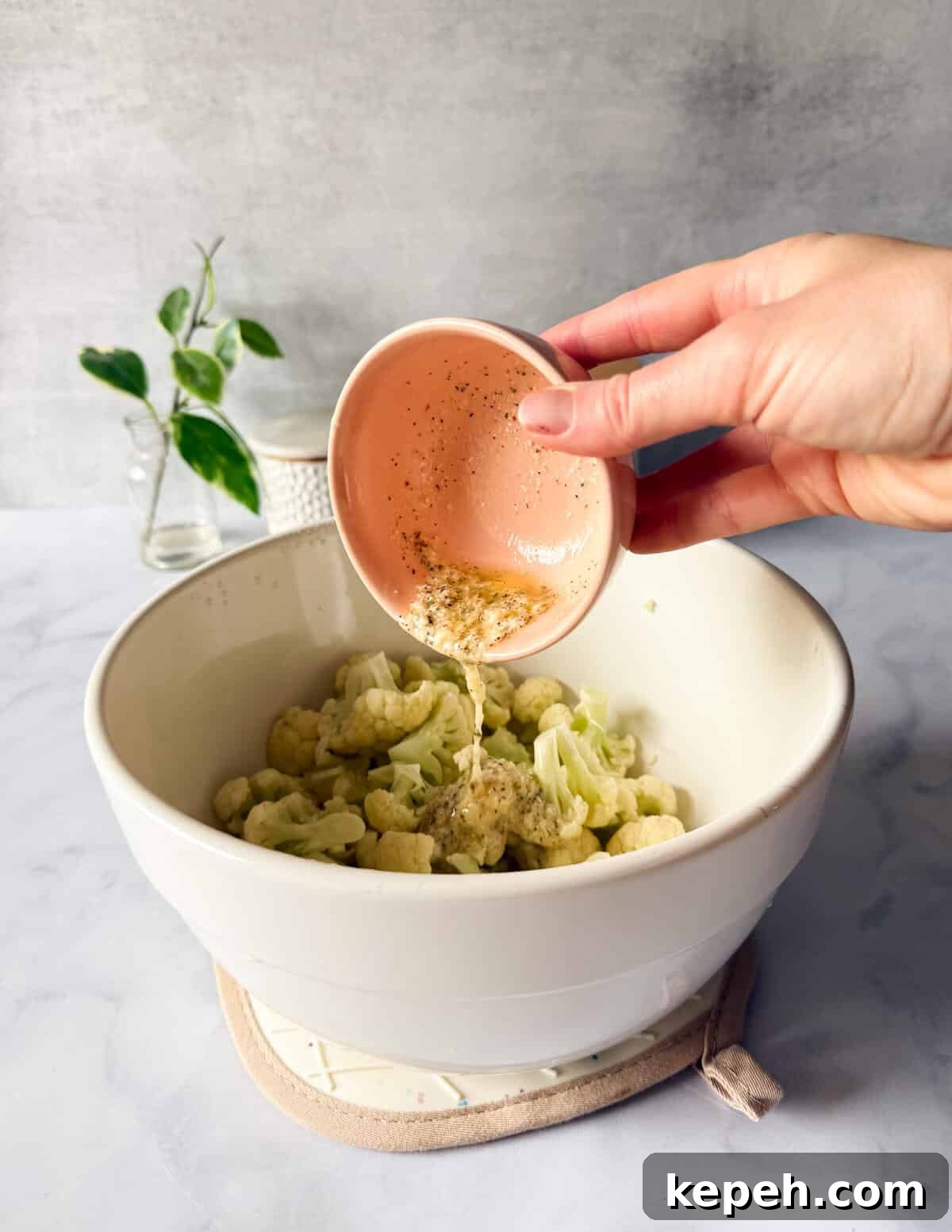 Garlic Butter Microwave Cauliflower Recipe for Quick Sides 10 pouring garlic butter on cooked cauliflower florets.