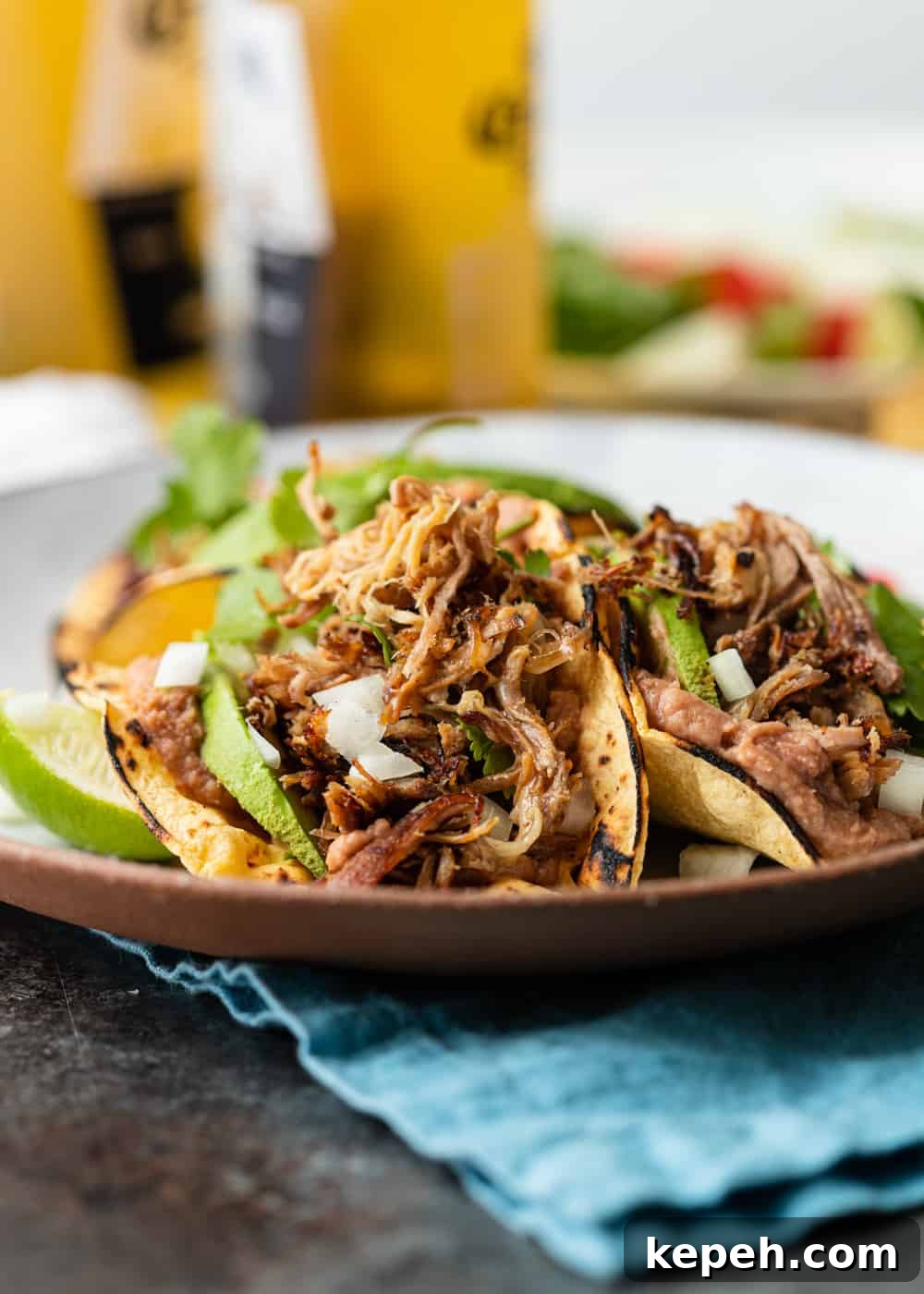teo carnitas tacos on a plate with onion cilantro avocado
