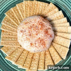 Spicy Chili Cheese Ball Recipe for Parties 4 Crackers in a circle around a chili cheese ball