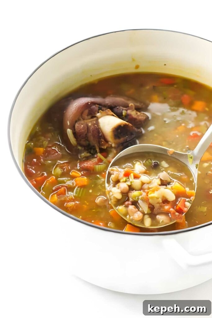 15-Bean Soup Recipe: Hearty, Protein-Packed Comfort Stew 4 White pot of mixed bean soup with ham hock, ladle lifting portion.
