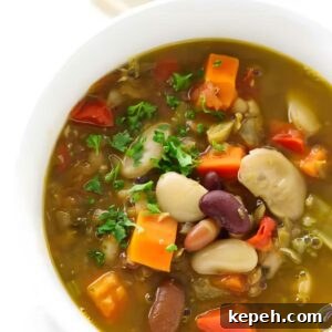 15-Bean Soup Recipe: Hearty, Protein-Packed Comfort Stew 6 Bowl of vegetable soup with beans, carrots, herbs, and parsley garnish.