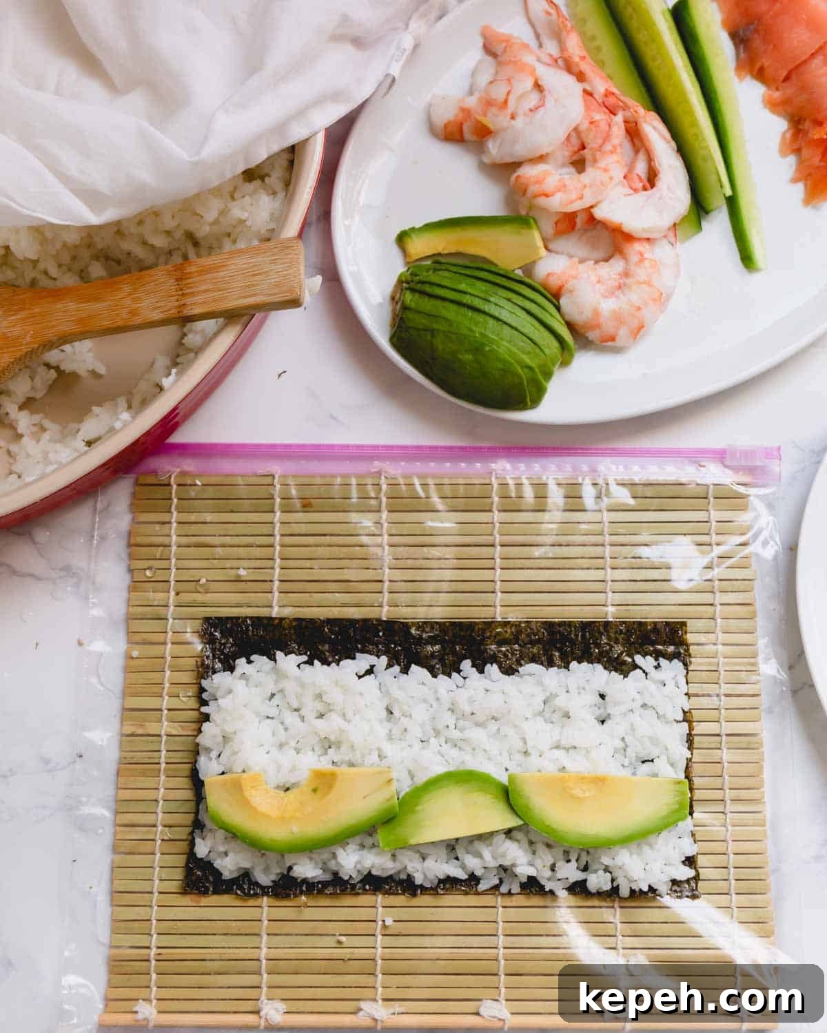 Homemade Sushi Roll Recipe: Step-by-Step Guide for Perfect Rolls 6 Nori sheet with rice and avocado slices on a bamboo mat.