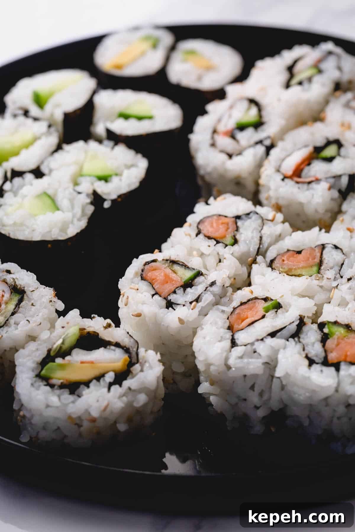Homemade Sushi Roll Recipe: Step-by-Step Guide for Perfect Rolls 7 Variety of homemade sushi rolls on black round platter.