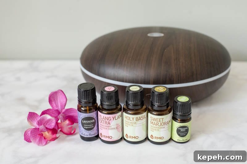 Renewed Patience: DIY Calming Essential Oil Blend for Moms 7 Lavender, ylang ylang, holy basil, sweet marjoram and coriander seed oil near a diffuser.