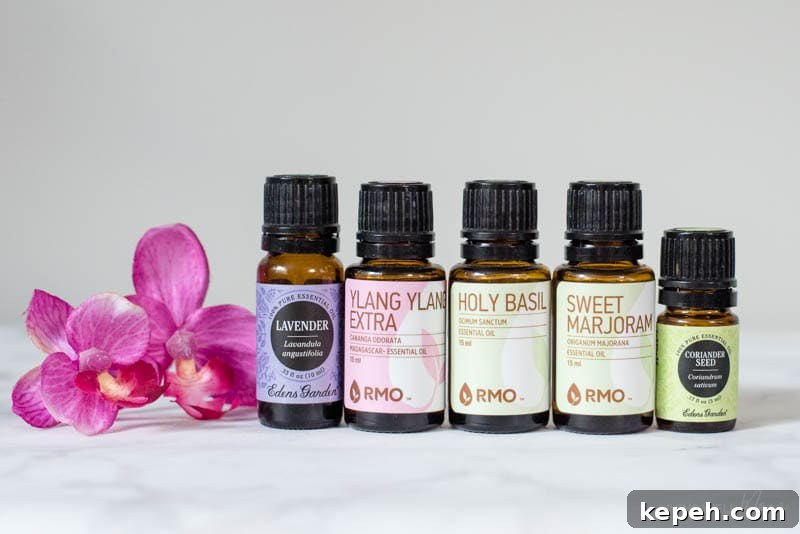 Renewed Patience: DIY Calming Essential Oil Blend for Moms 6 Bottles of calming essential oils next to a pink flower.