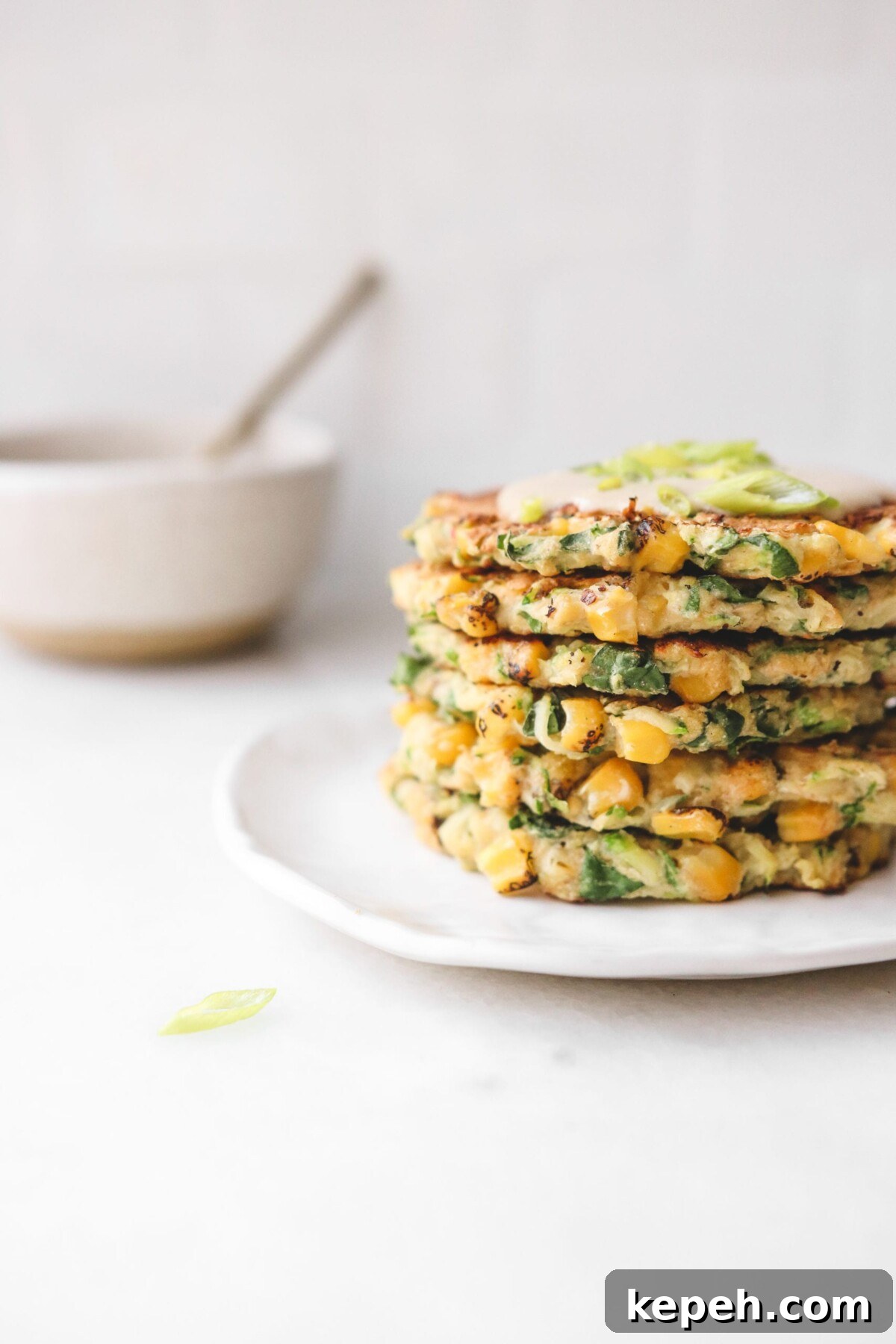 Crispy Gluten-Free Vegan Zucchini Fritters Recipe 4 an up close shot of crispy corn, kale, and zucchini made into a savory pancake