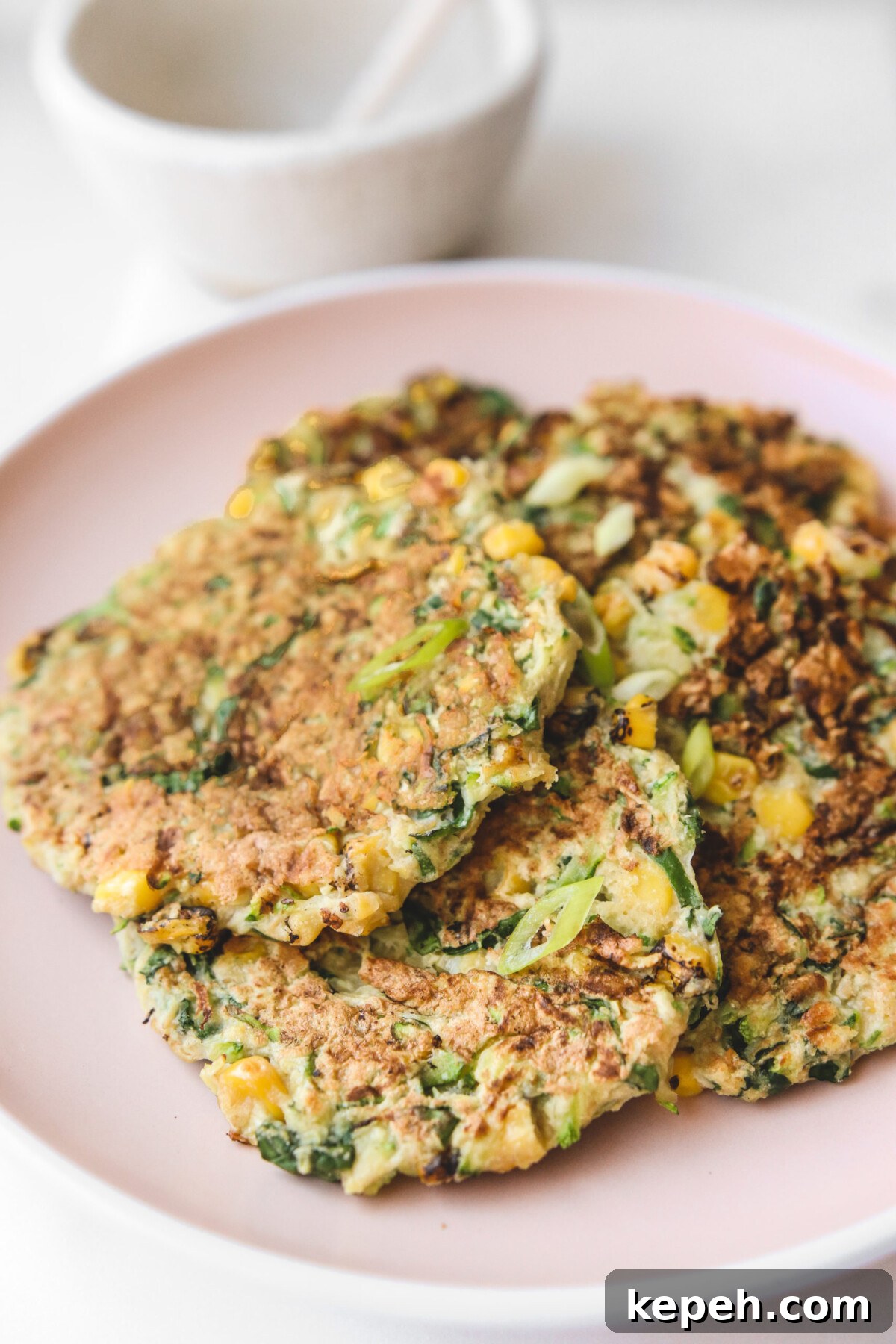 Crispy Gluten-Free Vegan Zucchini Fritters Recipe 5 scallions garnished on top of zucchini fritter pancakes