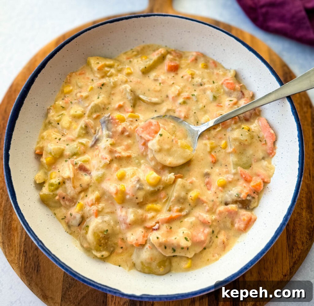 Creamy Salmon and Sweet Corn Chowder Recipe 2 creamy salmon chowder with corn and potatoes in a white bowl with a spoon