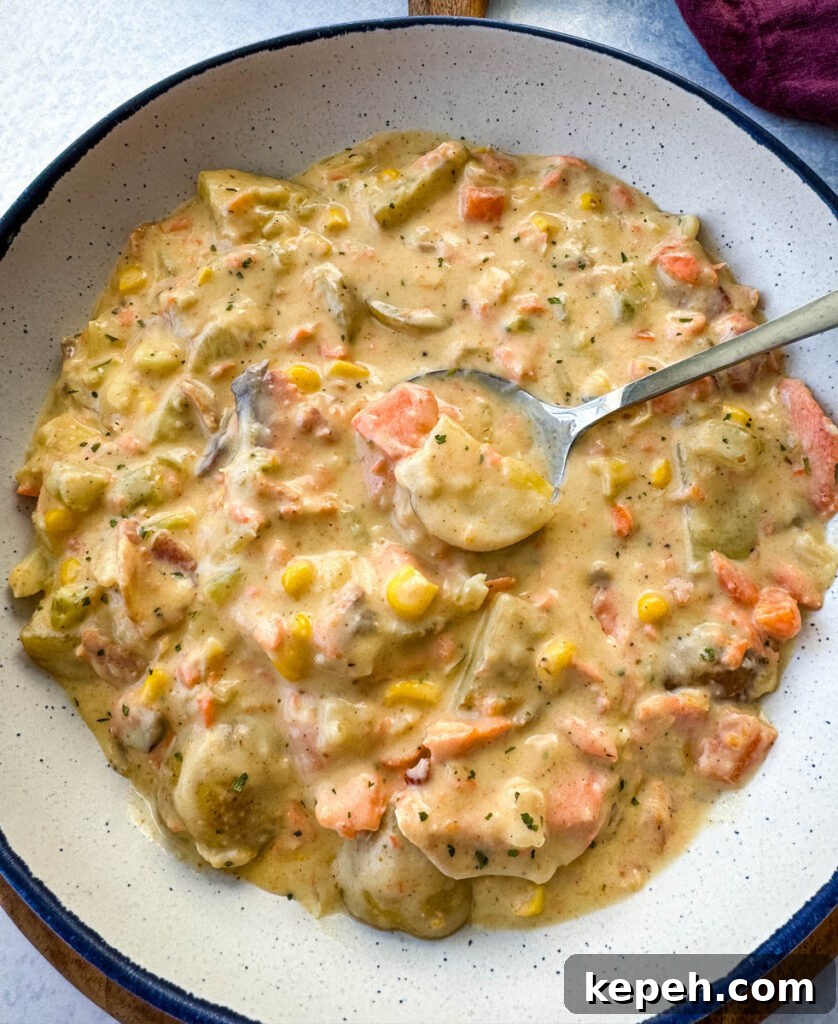 Creamy Salmon and Sweet Corn Chowder Recipe 11 creamy salmon chowder with corn and potatoes in a white bowl with a spoon